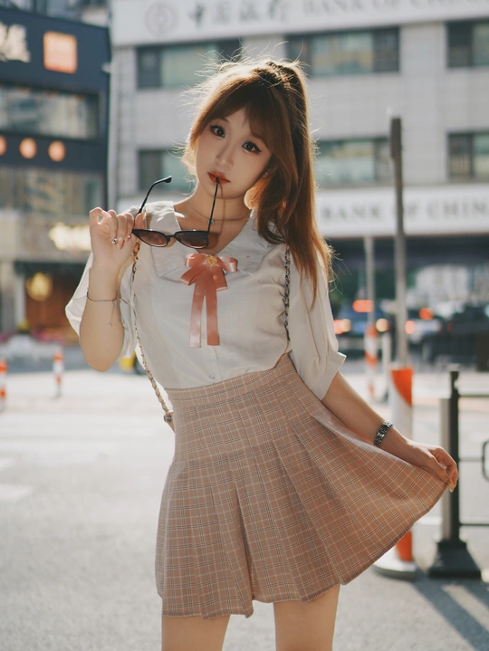 一位穿着裙子的年轻女子 嘴里叼着一支烟。