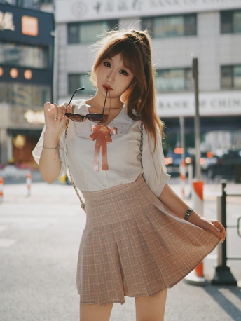 一位穿着裙子的年轻女子 嘴里叼着一支烟。