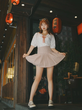 一位穿着裙子的年轻女子站在门口前