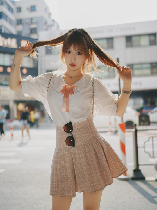 一位年轻女子穿着裙子在街上摆姿势