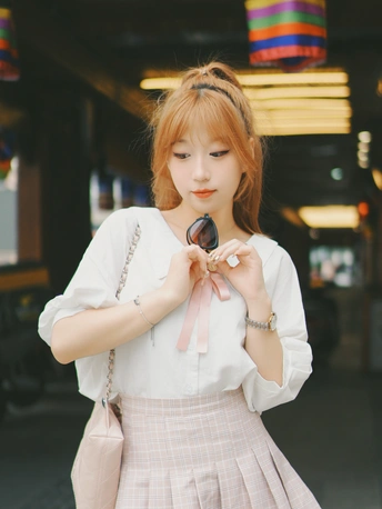 一位穿着白色连衣裙的年轻女子手持手机