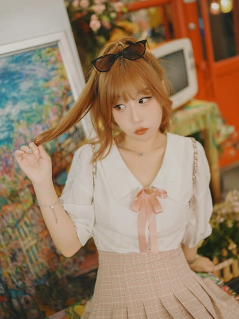 一位穿着白色衬衫和裙子的年轻女子正在为拍照摆姿势。