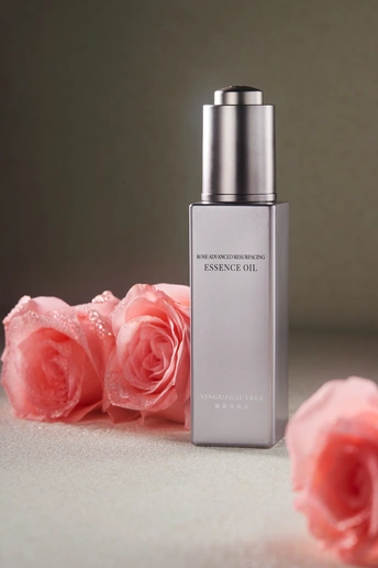 一瓶香水 旁边是粉红色玫瑰