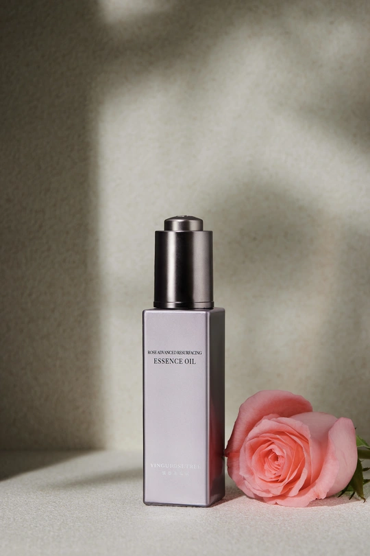 一瓶香水 旁边有一朵粉红色玫瑰