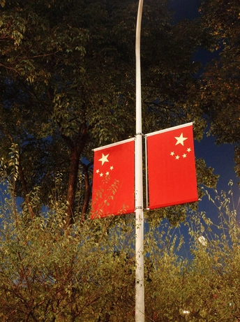 背景是树的旗杆上有六颗星的红旗