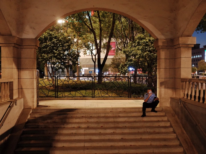 晚上 一个男人坐在公园拱门下楼梯上的长椅上 一个女人坐在楼梯上