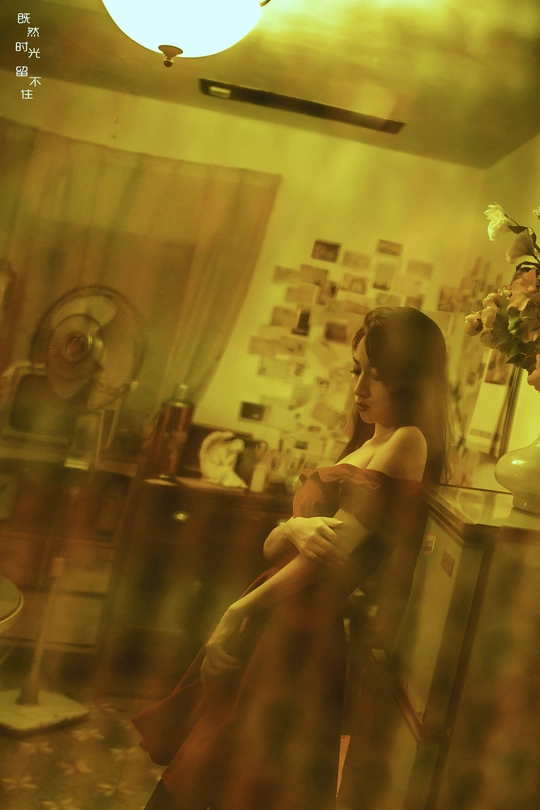 一个年轻女子坐在客厅的椅子上 对着镜子看。