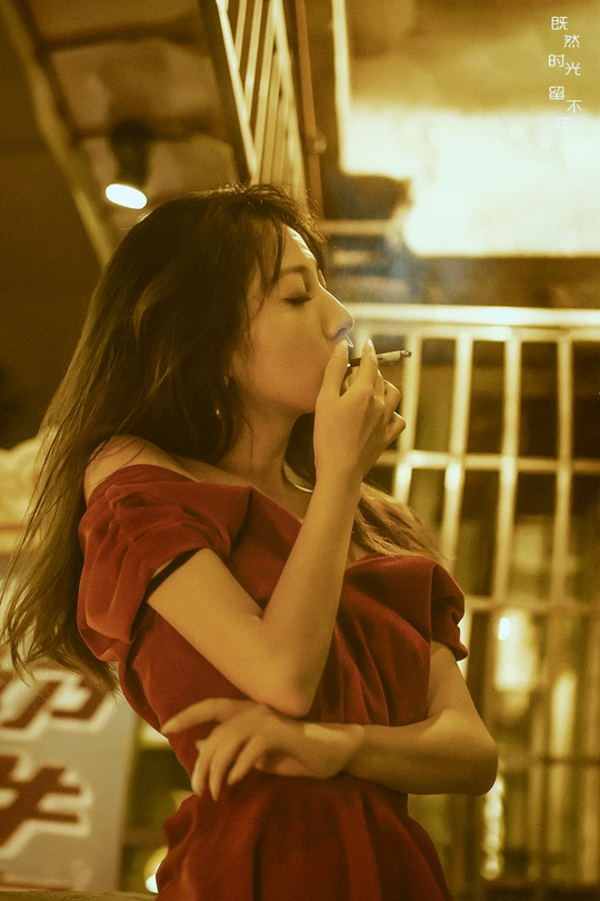 一个穿红裙子的年轻女子正在用手机通话