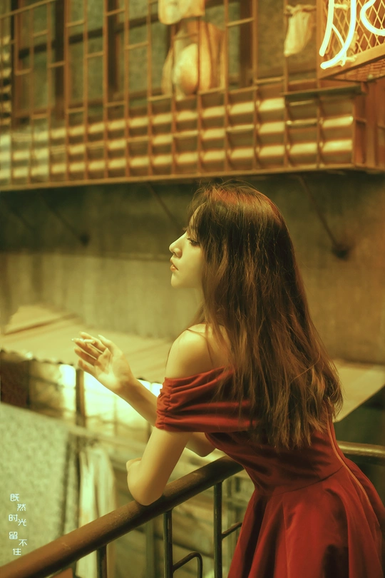 一个穿红裙子的年轻女子站在阳台上