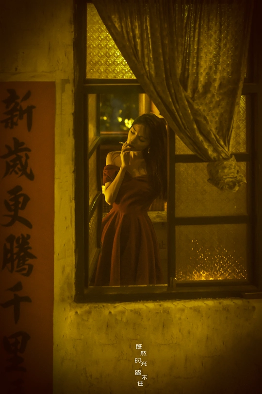 一位穿着红裙子的女人在夜晚的建筑中看镜子