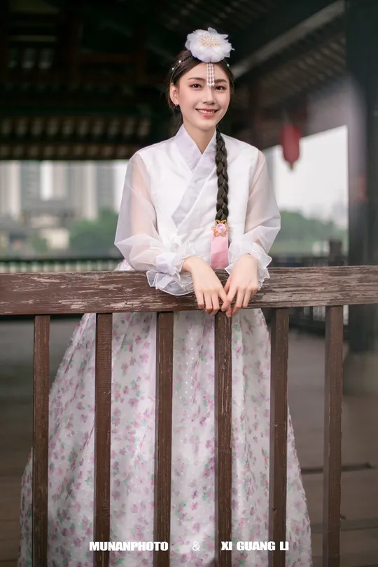 一位穿着传统韩国服装的年轻女子站立着。