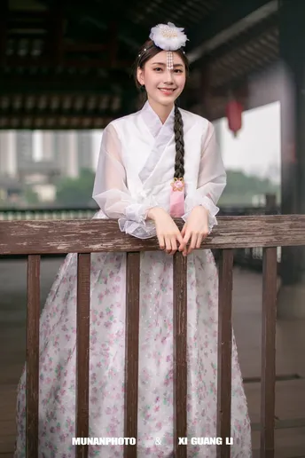 一位穿着传统韩国服装的年轻女子站立着。