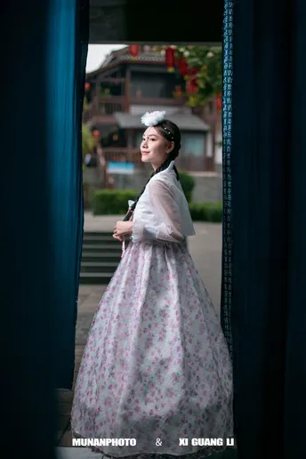 一位穿着连衣裙的女人站在窗户前