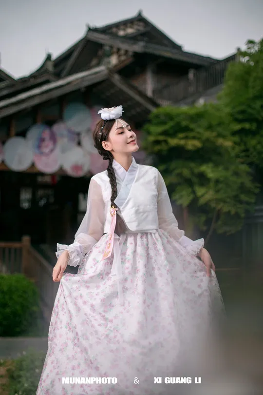 一位穿着传统服装并拿着雨伞的女人