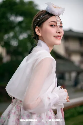 一位穿着传统服装的年轻女子 身着白色连衣裙。