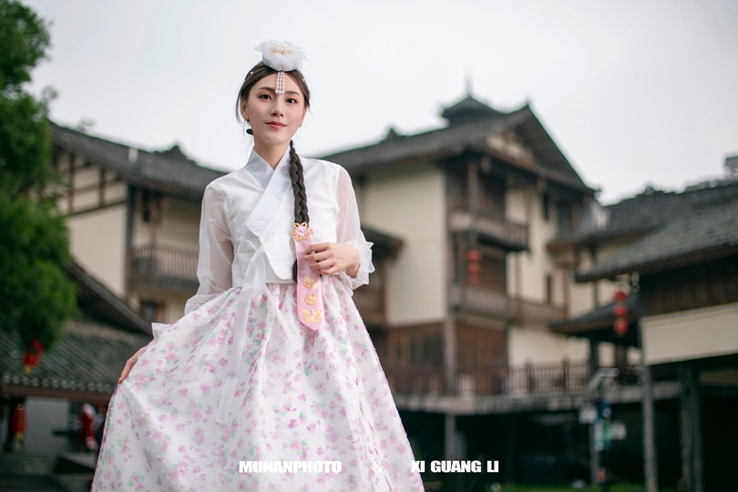 一位穿着传统服装的年轻女子打着雨伞