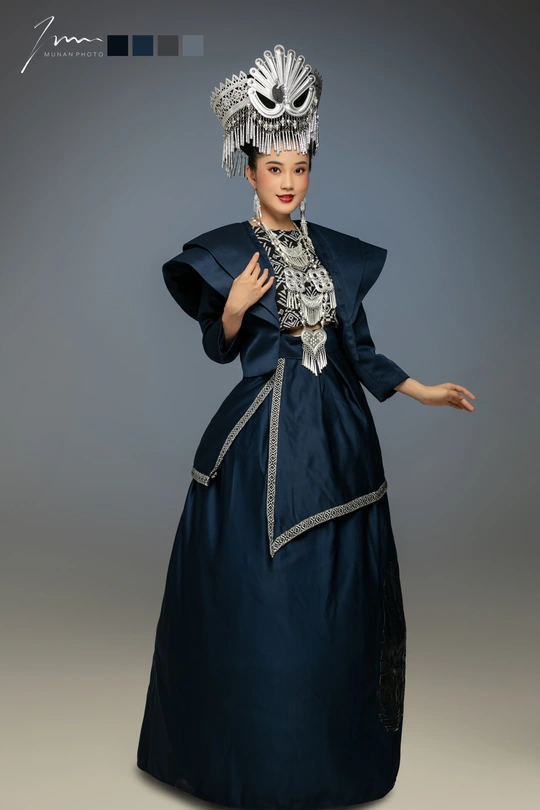 一位穿着传统服装的年轻女子在灰色背景上摆姿势