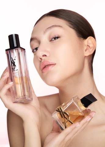 一位美丽的女人拿着一瓶香水