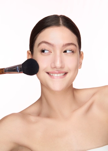 一位涂着妆容的年轻女子 手里拿着刷子