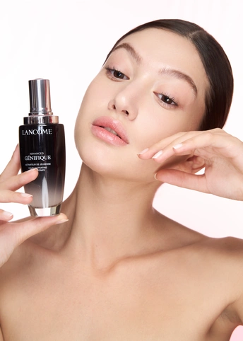 一位年轻漂亮的女子拿着一瓶香水