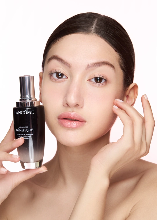 一位年轻漂亮的女子拿着一瓶香水