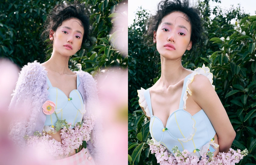 一位穿着蓝色连衣裙的女子在紫花丛前摆姿势拍照