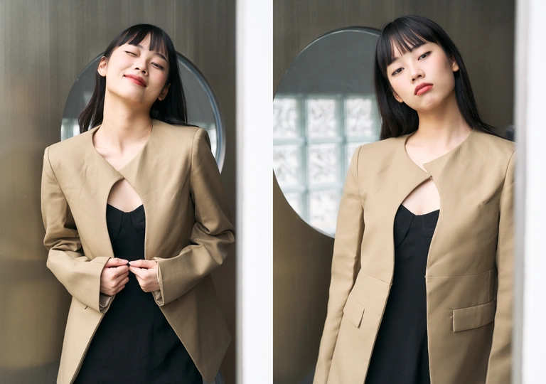 一位穿着黑色西装的女人站在镜子前