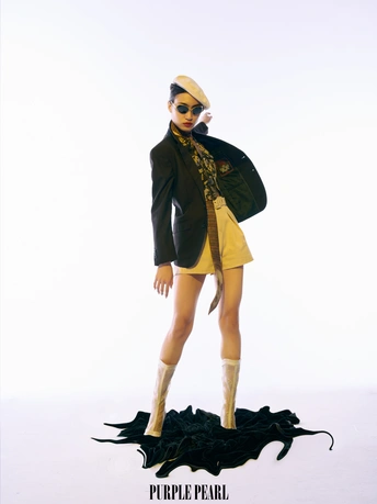 一个穿黄色外套和黑色裙子的洋娃娃