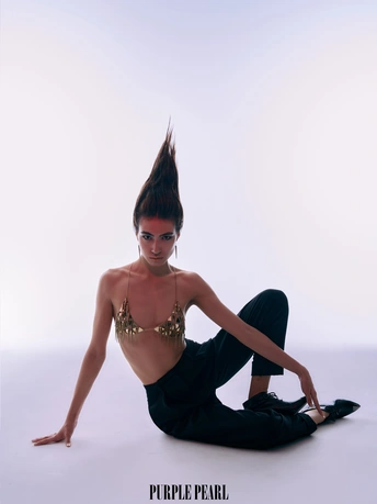 一个穿黑色衣服的年轻女子坐在白色的地板上 双腿交叉。