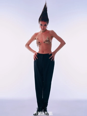 一个穿着黑色裤子的年轻女子站在白色背景上 身着舞蹈者的服装。