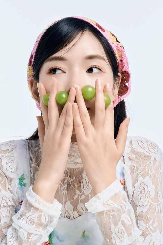 一位年轻女子用绿橄榄遮住眼睛 用双手捂住鼻子。