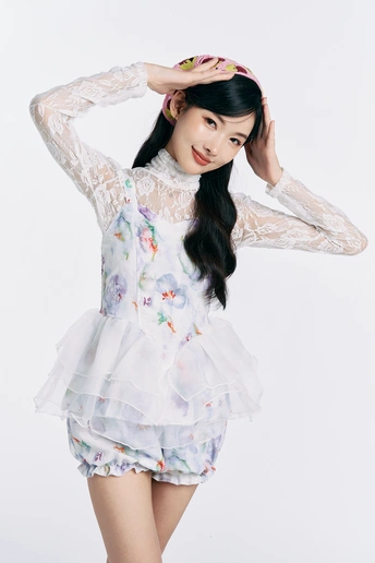 一位长发年轻女子穿着一件带有花的白色连衣裙