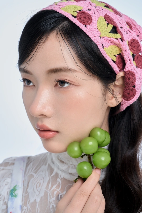 一位戴粉色帽子、绿色耳环的年轻女子