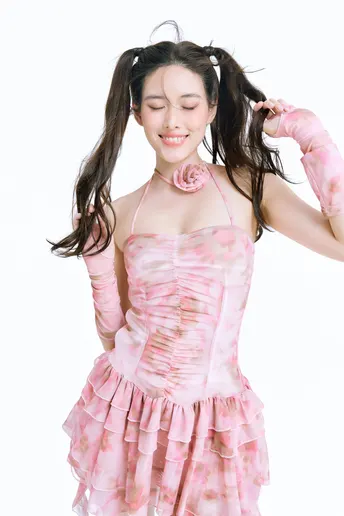 一位穿着粉色连衣裙上有玫瑰花的女青年