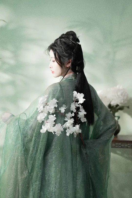 一位穿着绿色和服 上面有白色花朵的女孩