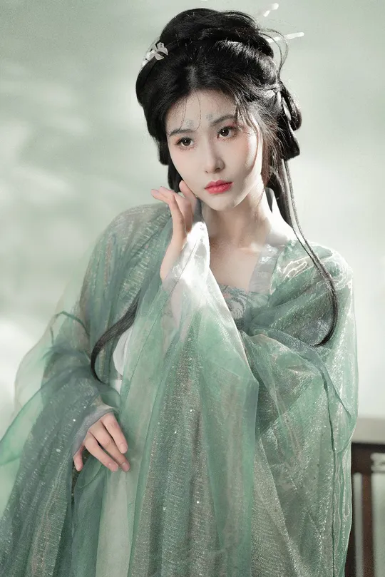 一位亚洲女性穿着一件绿色和白色的连衣裙