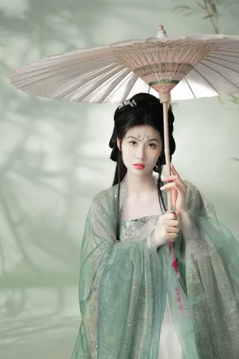 一尊穿着绿裙子的女人雕像 手里拿着一把伞