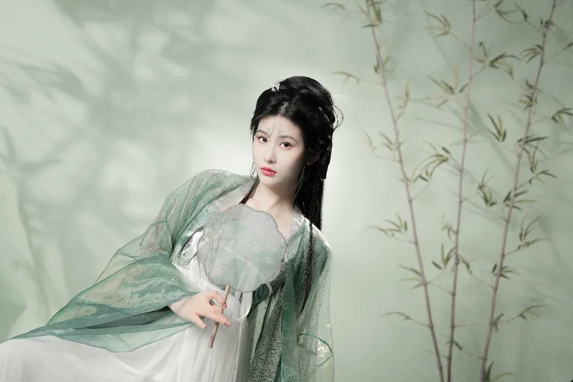 一位穿着白色连衣裙 手持绿色雨伞的美丽年轻女士