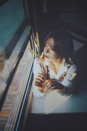 一个小女孩看着窗外一个拿着花的年轻女子