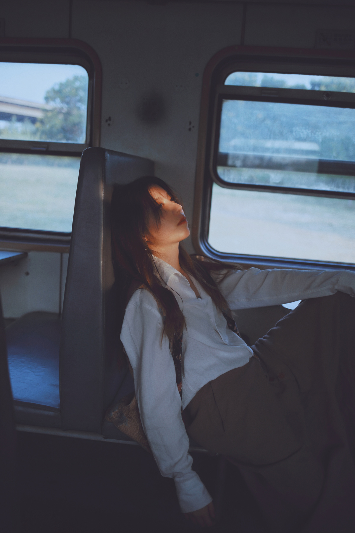 一个坐在火车上看着窗外的年轻女子