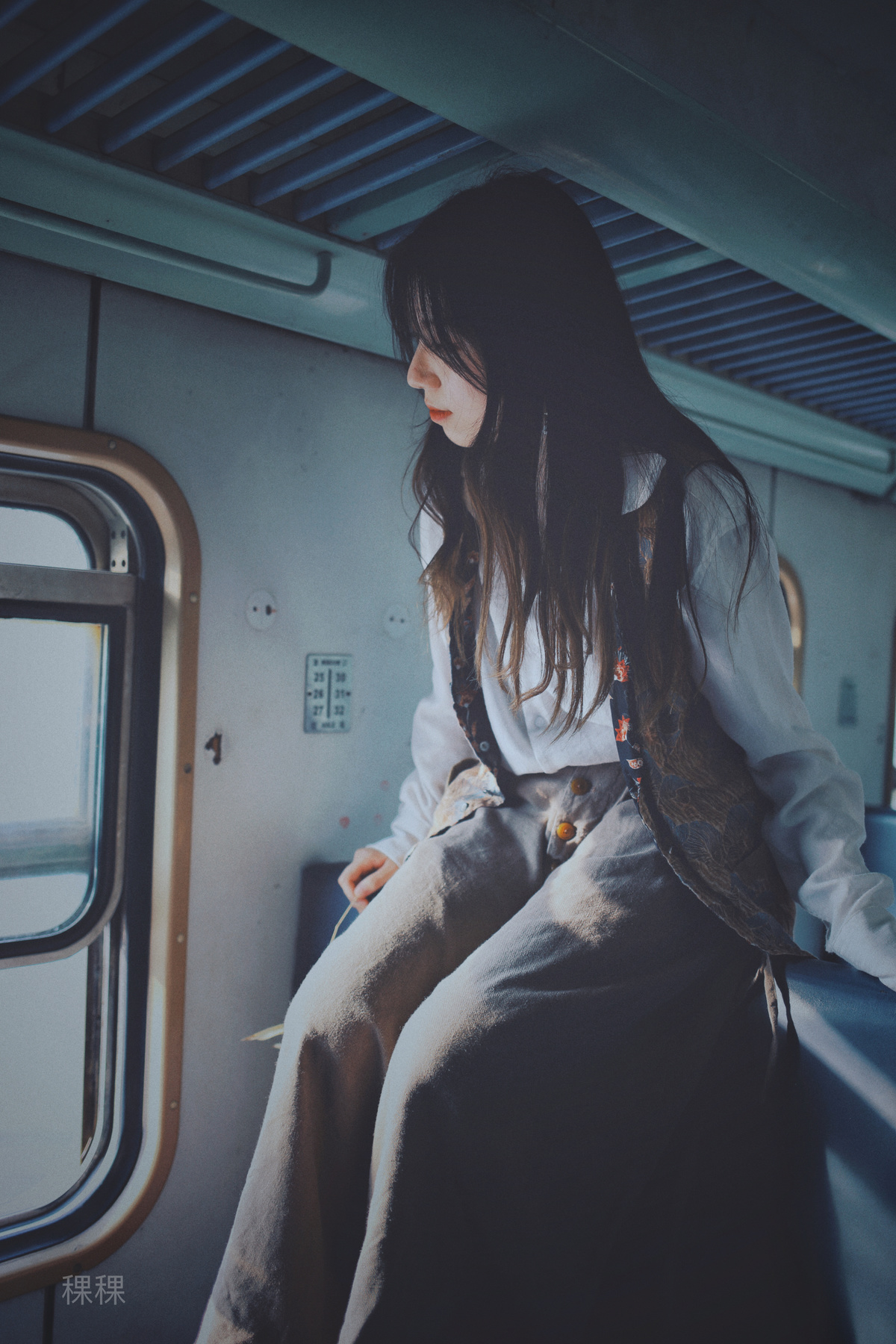一个坐在地铁上看着窗外的年轻女子