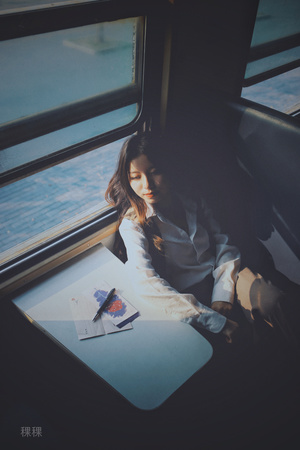 一个坐在火车上的年轻女子望着窗外的一张桌子