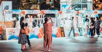 一位妇女和小孩站在夜晚的街道上