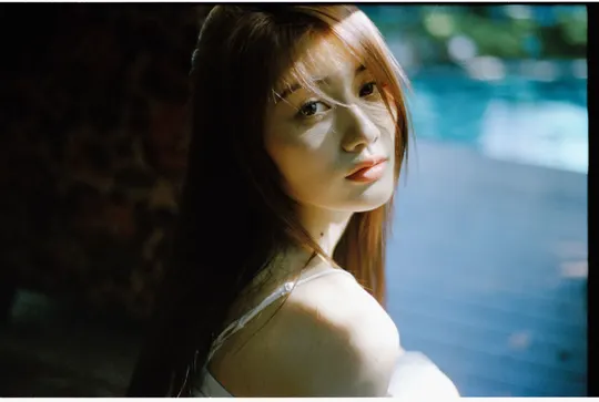 一位穿白裙子的女孩站在窗前