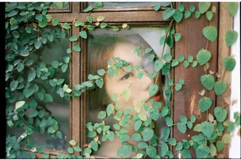 一位女士正在查看一所房子的窗户