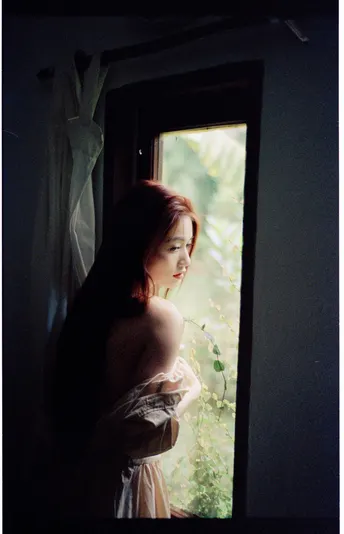 一位女士正在窗口向外看