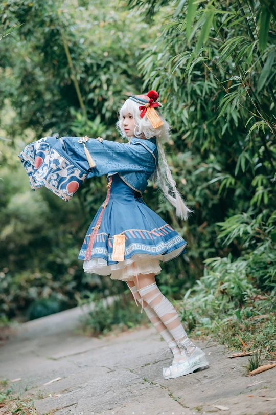 一位穿着蓝色连衣裙 手持雨伞在路上的女士