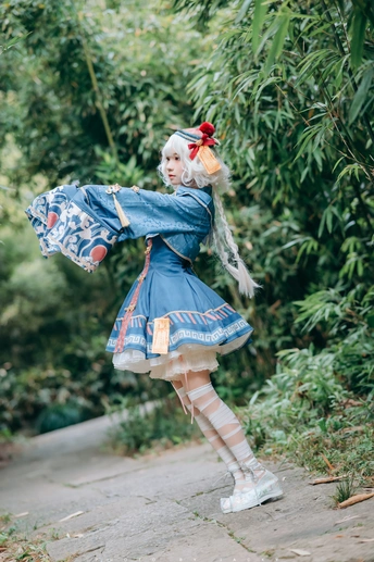 一位穿着蓝色连衣裙 手持雨伞在路上的女士
