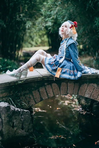 一个年轻女孩坐在水上的桥上