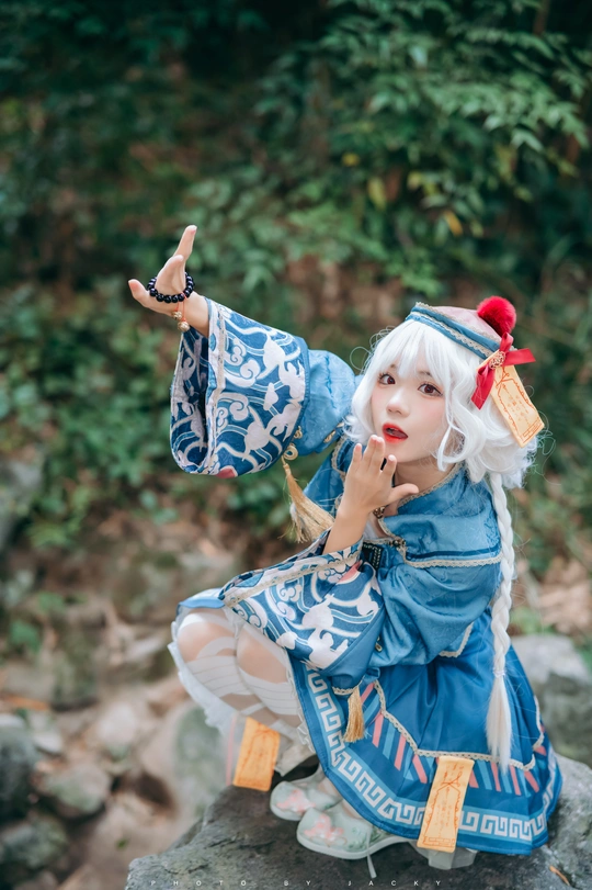 一位穿着蓝色服装的女人坐在岩石上